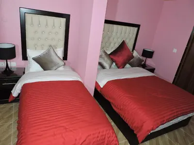 two beds in a room with red and white at Valentine Inn Luxury in Wadi Musa