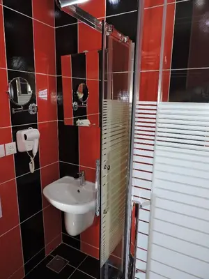 a bathroom with a sink and red tile walls at Valentine Inn Luxury in Wadi Musa
