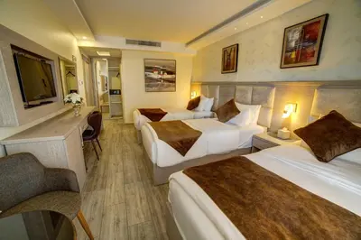 a hotel room with two beds and a television at Laverda Hotel in Aqaba