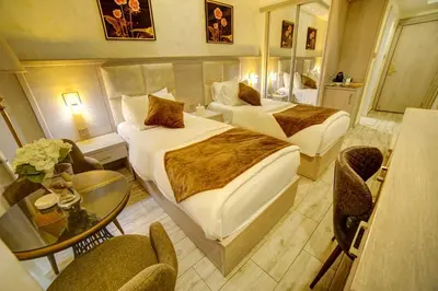 a hotel room with two beds and a table and chairs at Laverda Hotel in Aqaba