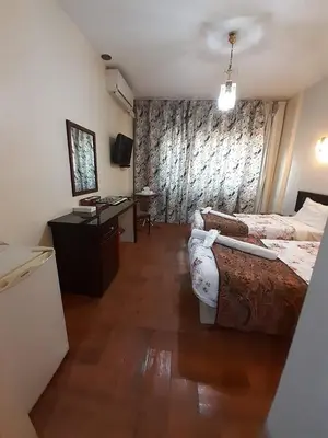 a hotel room with a bed and a desk and a room at Amman Ambiance Hotel in Amman
