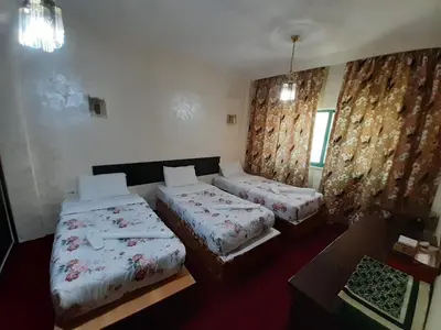 a hotel room with two beds and a window at Amman Ambiance Hotel in Amman