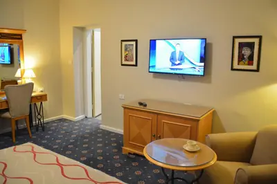 a living room with a couch and a tv on the wall at The Y Hotel in Amman