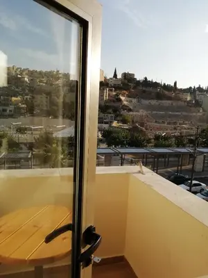 a room with a window with a view of a city at Layaali Amman Hotel in Amman
