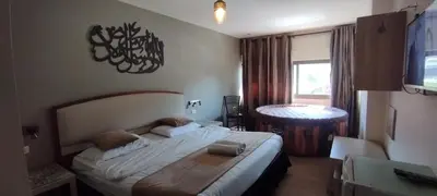 a bedroom with a large bed and a table at Layaali Amman Hotel in Amman