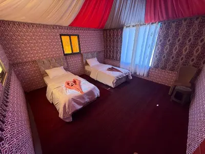a room with two beds and a dog laying on the bed at Myra Stars Camp & Tours in Wadi Rum