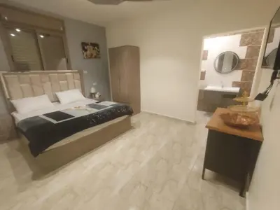 a bedroom with a large bed and a table at Darkum Apartment in Wadi Musa