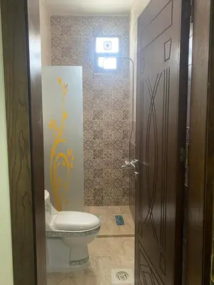 a bathroom with a toilet and a door open at Darkum Apartment in Wadi Musa