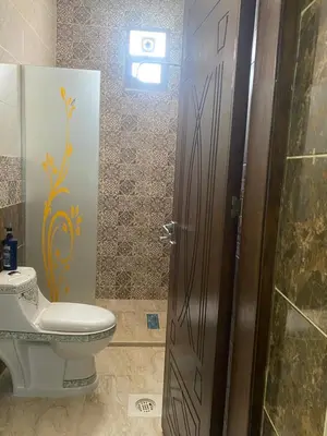 a bathroom with a toilet and a glass door at Darkum Apartment in Wadi Musa