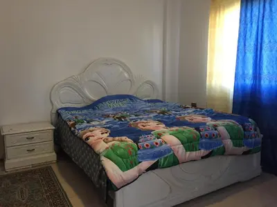 a bedroom with a large bed with a white frame at PALM Home in Amman