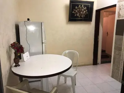 a white table and chairs in a kitchen with a refrigerator at PALM Home in Amman