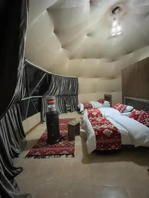 two beds in a room with a ceiling at Zarb Desert Camp in Wadi Rum