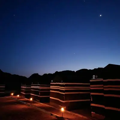 a row of buildings at night with a blue sky at Wadi Rum Bedouin Heart in Wadi Rum