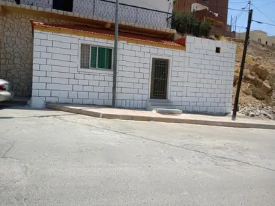 a white brick building with a door on a street at Idris home in Wadi Musa