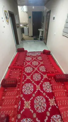 a large red rug on the floor of a room at Idris home in Wadi Musa
