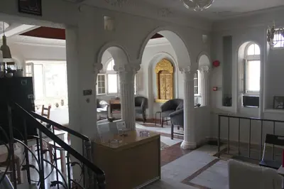 a living room with arches and a table and chairs at Cairwan Hotel in Kerak