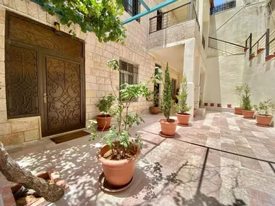 a courtyard with potted plants in front of a door at Villa Mira Guesthouse 1 - Downtown Central Amman - AL DIYRIH in Amman