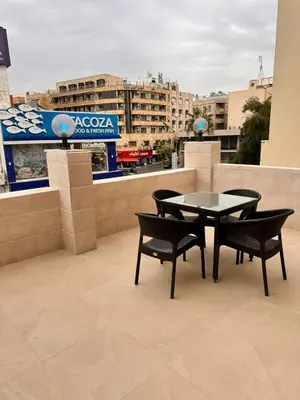 a patio with a table and chairs on a roof at ArwaHotel Apartments اروى للشقق الفندقية in Aqaba