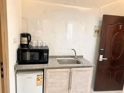 a kitchen with a sink and a microwave at ArwaHotel Apartments اروى للشقق الفندقية in Aqaba