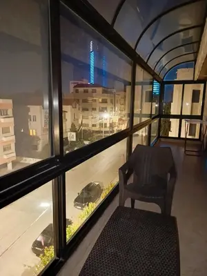 a chair sitting in a room with a window at Nice Furnished apartment in Amman