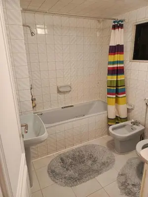 a bathroom with a tub and a toilet and a sink at Nice Furnished apartment in Amman