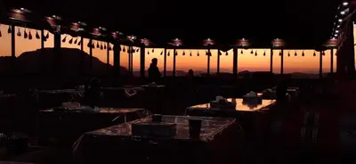 a person walking in the dark with a person standing in the background at Desert Bedouin camp in Wadi Rum