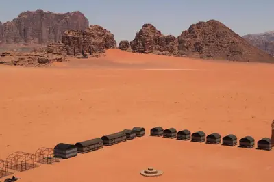 a row of seats in the desert with a pyramid at Desert Bedouin camp in Wadi Rum