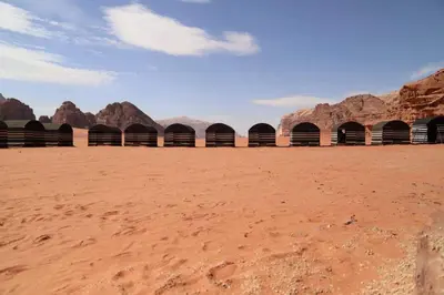 a desert with a row of buildings in the desert at Desert Bedouin camp in Wadi Rum