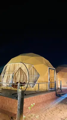 a domed building with a cover on a beach at Faisal Wadi Rum Camp in Wadi Rum