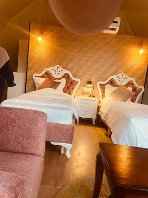 a bedroom with two beds and a couch at Faisal Wadi Rum Camp in Wadi Rum