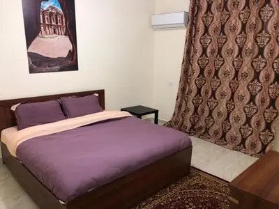 a bedroom with a bed with purple sheets at Rakan ApartHotel and Luxury Rooms in Wadi Musa