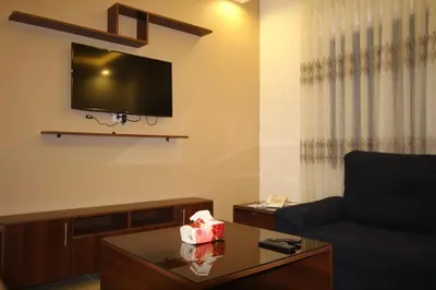 a living room with a couch and a tv on the wall at سما عمان للشقق الفندقية Sama Amman Hotel Apartments in Amman
