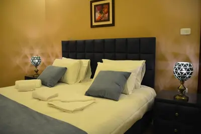 a large bed with white sheets and pillows at سما عمان للشقق الفندقية Sama Amman Hotel Apartments in Amman