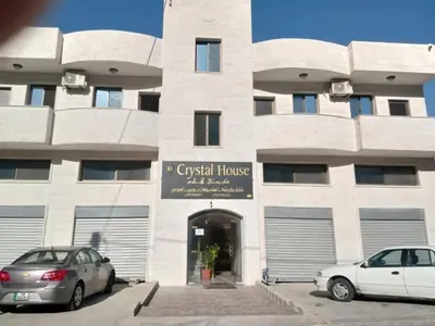 two cars parked in front of a building at Petra Monastery Tourist Hotel in Wadi Musa