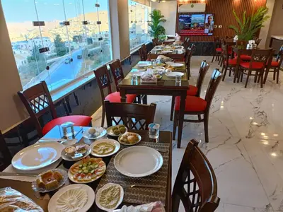 a dining room with tables with plates of food at Petra Monastery Tourist Hotel in Wadi Musa