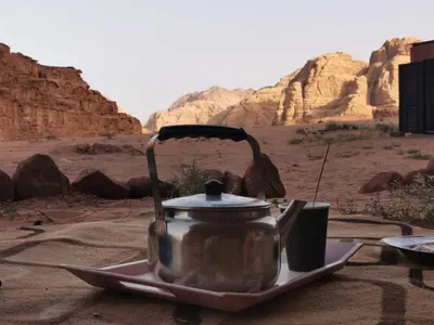 a tea kettle on a plate in the desert at Wadi Rum night soul Camp in Wadi Rum