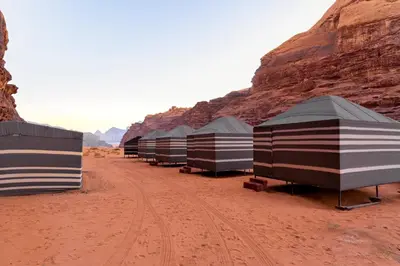 a row of tents in the desert near a mountain at Wadi Rum night soul Camp in Wadi Rum