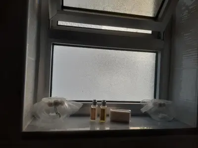 a bathroom window with two bottles and a candle at The Place in Madaba