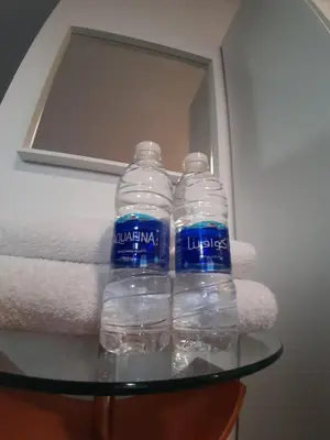 two bottles of water sitting on a glass table at The Place in Madaba