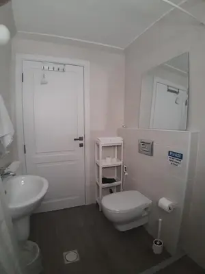 a white bathroom with a toilet and a sink at The Place in Madaba