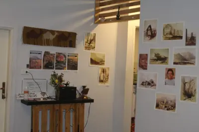 a wall with pictures and pictures on it at Petra Main Gate in Wadi Musa