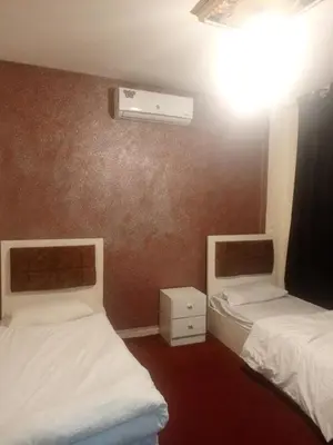 a room with two beds and a air conditioner at Jarajreh Apartments/ Hotel in Kerak