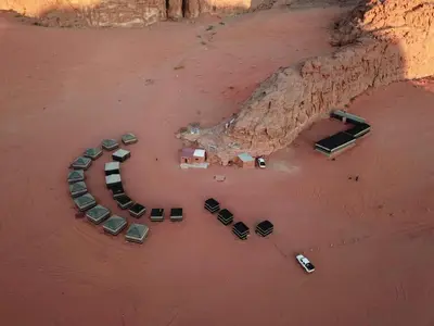 an aerial view of a bunch of cars parked on the beach at Wadi rum desert breath in Wadi Rum