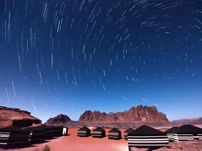 a starry night with star trails in the desert at Wadi rum desert breath in Wadi Rum