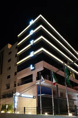 a tall building with a flag in front of it at Diamond Hotel in Amman