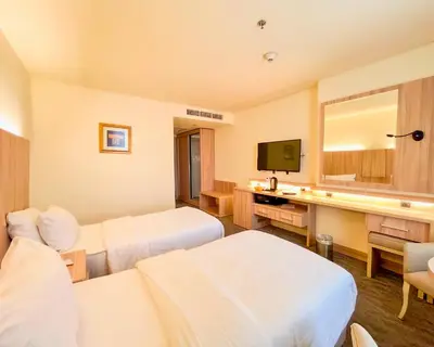 a hotel room with two beds and a television at La Casa Hotel Amman by FHM in Amman