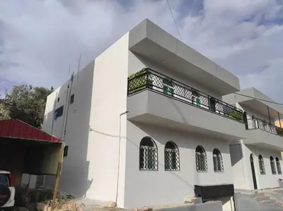 a white building with a balcony on the side of it at Oskar Appartment 2 in Wadi Musa