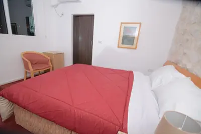 a bedroom with a red blanket on a bed at Petra Lion Hotel in Wadi Musa