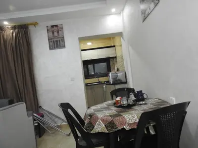 a dining room table with chairs and a kitchen in a room at Amro Petra Apartment in Wadi Musa