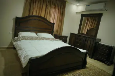 a bedroom with a large bed and a mirror at Amro Petra Apartment in Wadi Musa